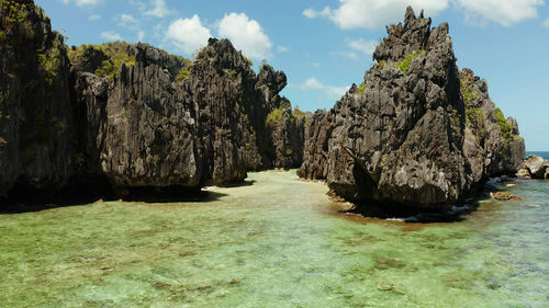 Aerial view of tropical lagoon with sandy beach surrounded by cliffs. el nido, philippines, palawan.