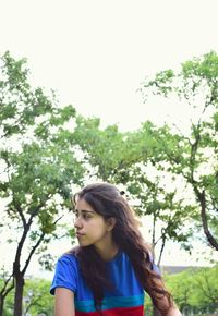 Portrait of young woman against tree