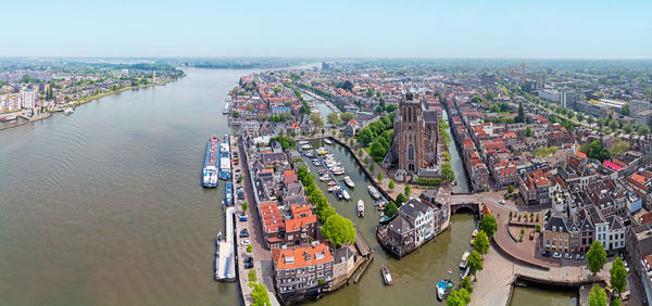 High angle view of cityscape by sea against sky