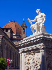 Low angle view of statue against blue sky