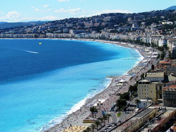 Scenic view of sea by town against sky