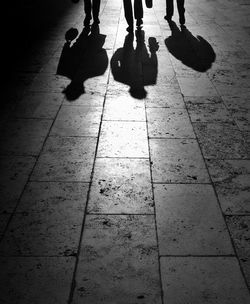 Low section of people standing on tiled floor