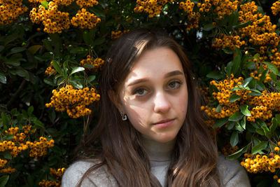 Portrait of beautiful young woman with red flower