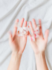 Cropped hands of woman with iv drip on bed