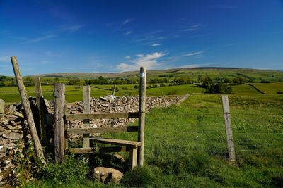 Wooden fence on field against sky