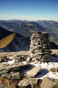 Stack of stones at mountain peak against landscape