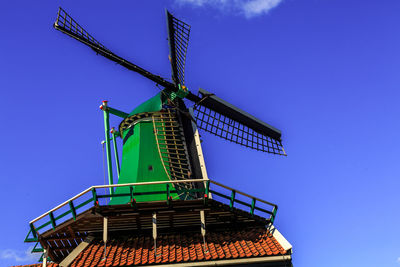 Low angle view of traditional windmill against blue sky