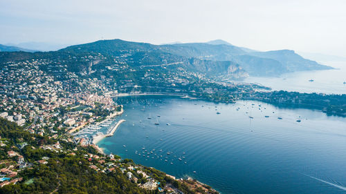 High angle view of city by sea against sky