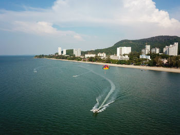 Scenic view of sea by buildings against sky