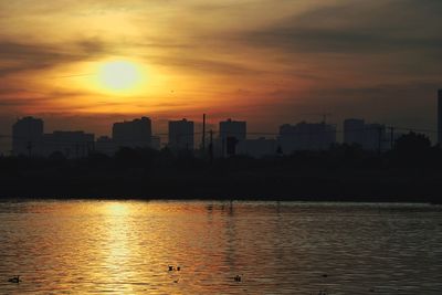 Silhouette buildings against sky during sunset