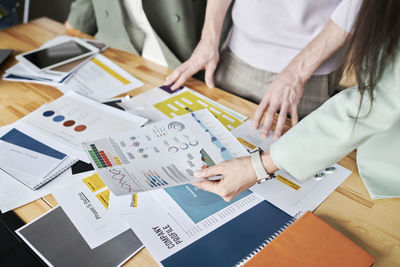 Office colleagues reviewing infographics on desk at office