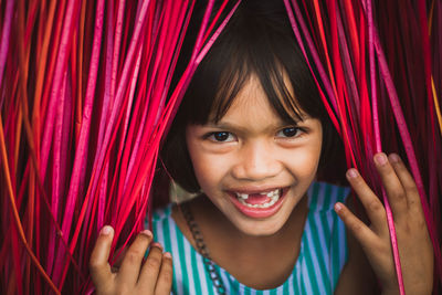 Portrait of smiling girl by curtain