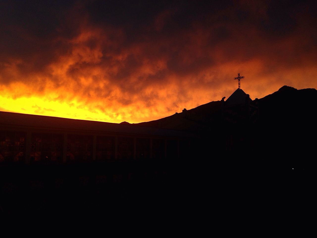 sunset, silhouette, architecture, building exterior, built structure, dusk, sky, cloud - sky, orange color, mountain, scenics, tranquility, dramatic sky, tranquil scene, cloud, outline, storm cloud, cloudy, outdoors, dark, no people, beauty in nature, high section, majestic, moody sky