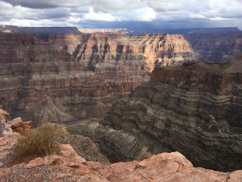 Rock formations on landscape against cloudy sky