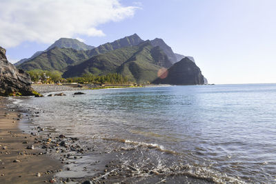 Scenic view of sea and mountains against sky
