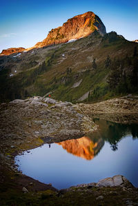 Scenic view of lake by mountain against sky