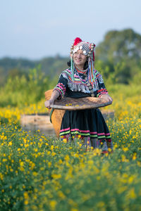 Woman with yellow flower in field