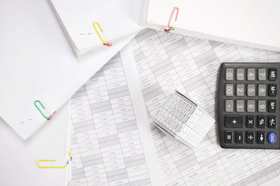 High angle view of model house and calculator on financial documents