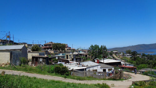 Houses and buildings against clear blue sky