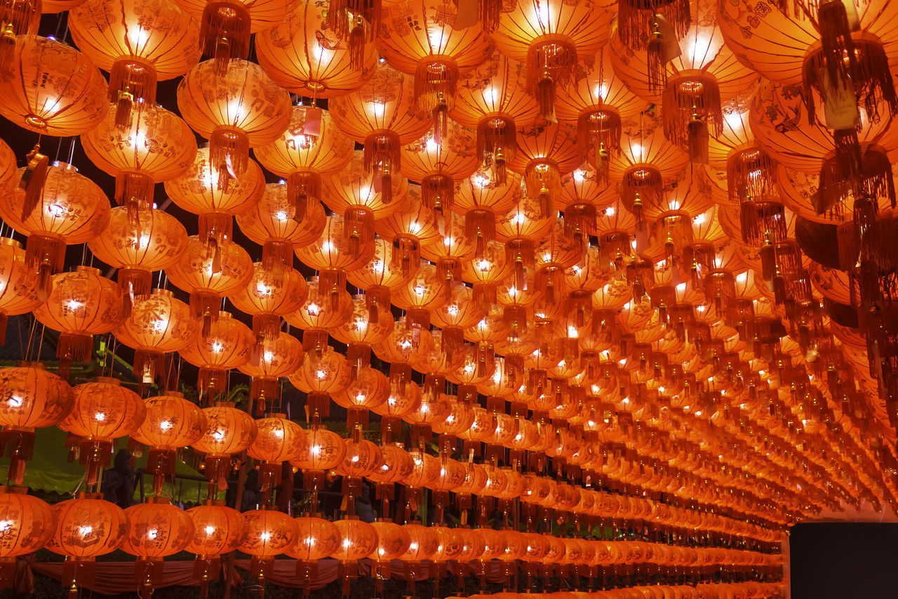 LOW ANGLE VIEW OF ILLUMINATED LANTERNS HANGING IN CEILING