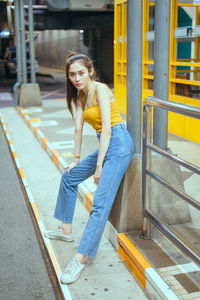 Portrait of young woman at railroad station platform