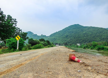 View of road amidst trees against sky