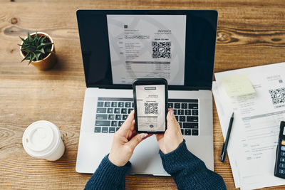 Low section of woman using laptop on table