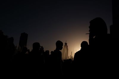 Silhouette of people against clear sky during sunset