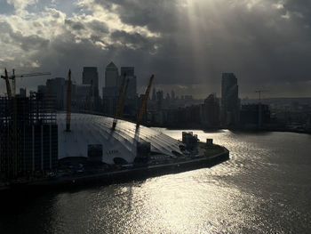 Panoramic view of river and buildings against sky during sunset