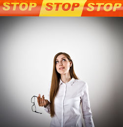 Portrait of woman standing against wall