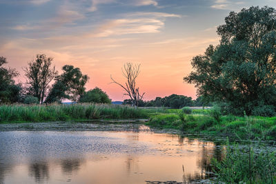 Scenic view of lake against sky at sunset