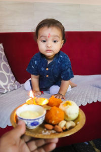 Cute infant looking trying to eat sweets on the occasion of raksha bandhan