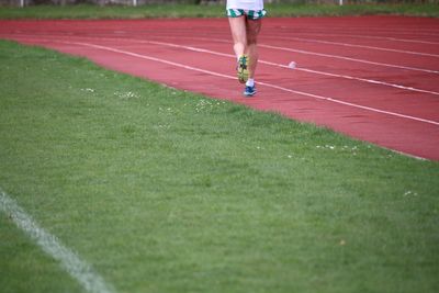 Low section of man running on sports track