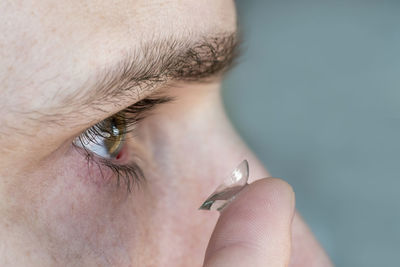 Cropped image of man putting contact lens