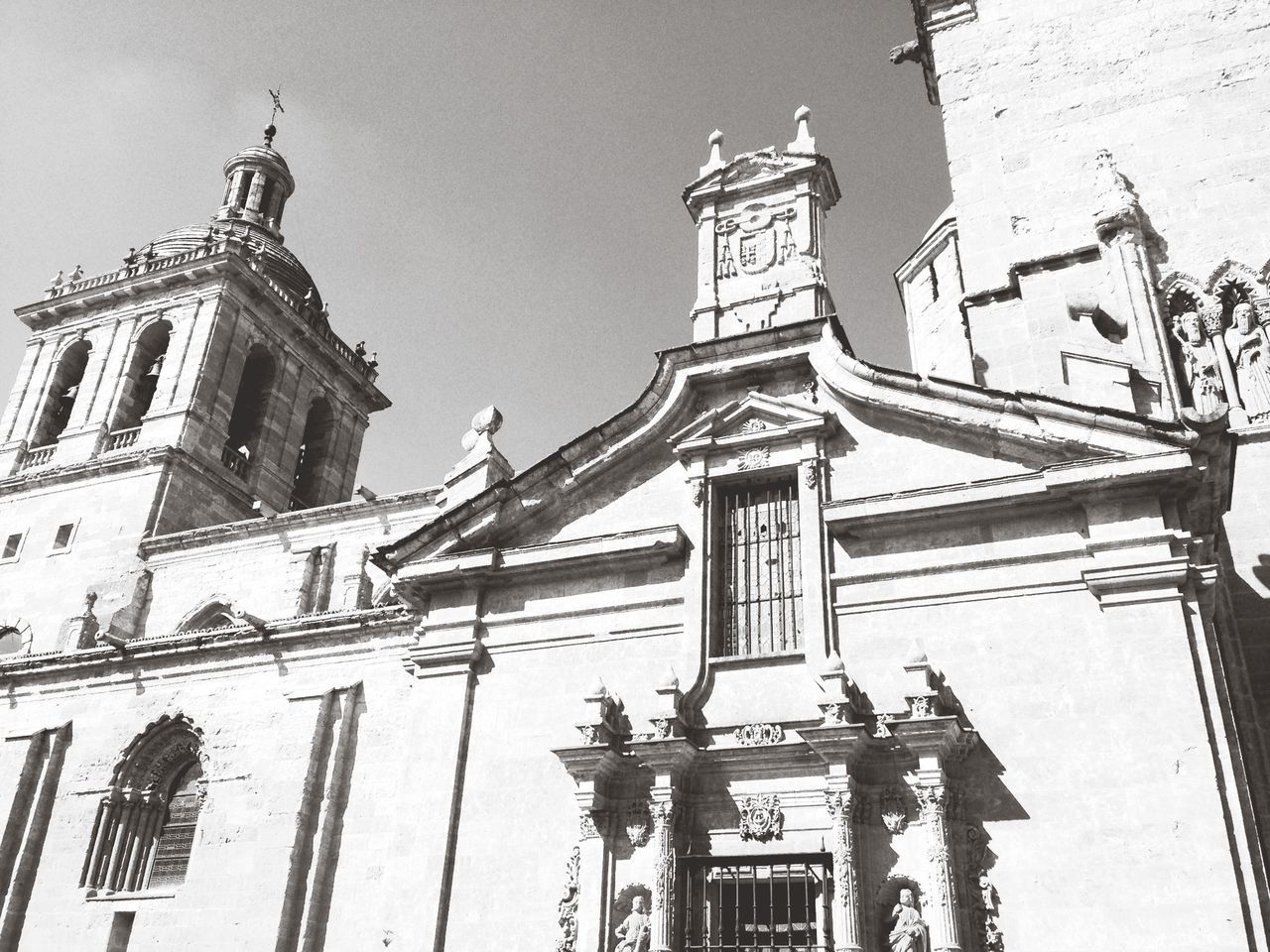 low angle view, architecture, building exterior, built structure, clear sky, church, religion, place of worship, sky, tower, day, city, outdoors, high section, spirituality, no people, clock tower, street light, building