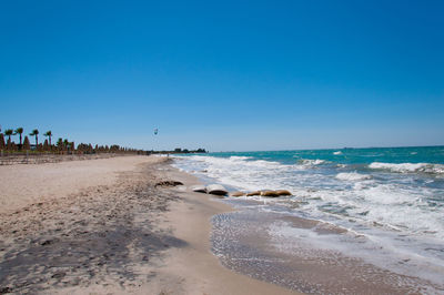 Scenic view of beach against clear blue sky