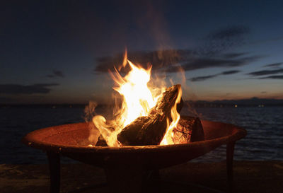 Wood burning at beach during dusk