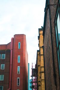 Low angle view of buildings against cloudy sky