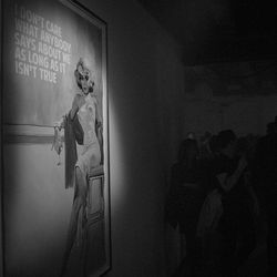 Young woman standing against wall at night