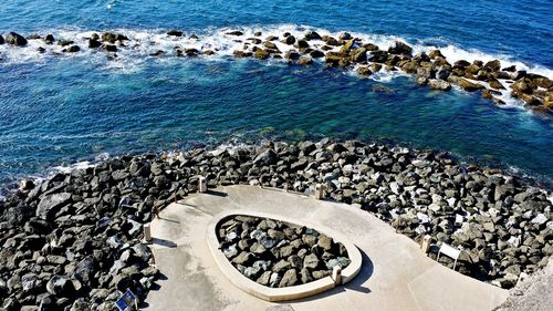 High angle view of rocks in sea on sunny day