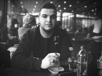 Portrait of man with drink sitting in restaurant