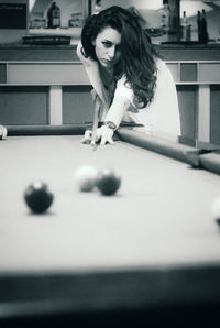 Young woman playing with ball on table