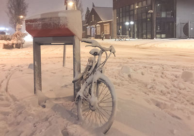 Bicycle on snow in city at night