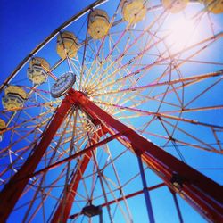 Low angle view of ferris wheel against blue sky