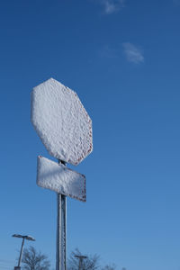 Stop sign covered in snow against a clear sky