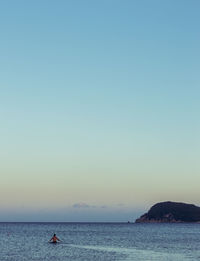 Rear view of shirtless man in sea against sky