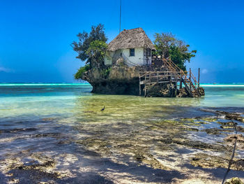 House by sea against blue sky