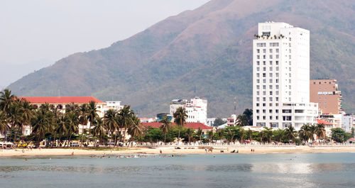 Scenic view of beach by city against sky