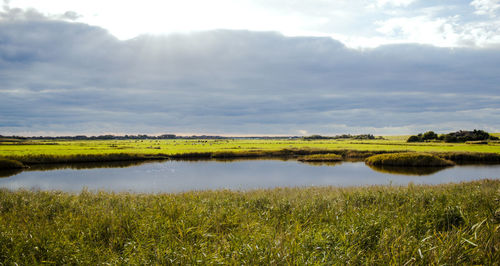 Scenic view of lake against cloudy sky