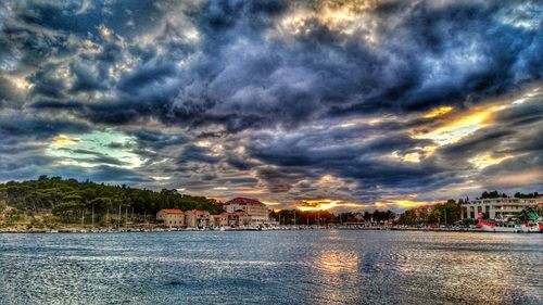 Scenic view of river against cloudy sky